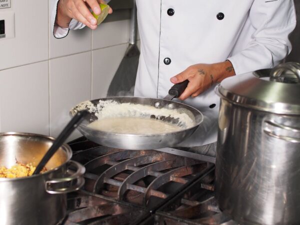 chef preparing creamy sauce in professional kitchen