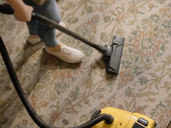 person using a yellow and black vacuum cleaner
