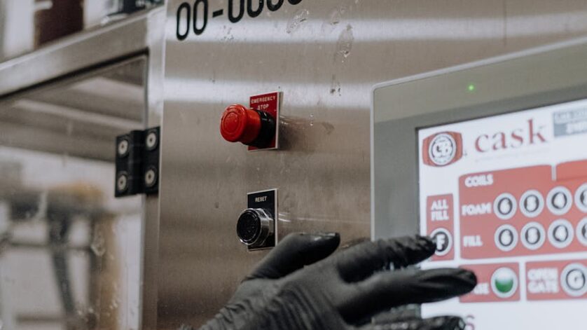 person with black gloves in hand holding a machine