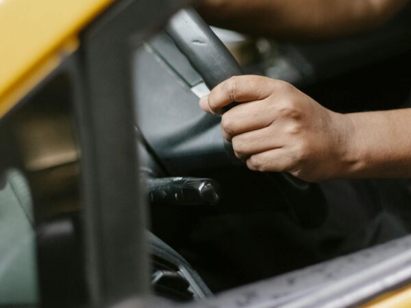 crop unrecognizable man driving cab in daytime